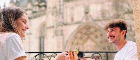 Two people sitting at a table outdoors with a historic building in the background.