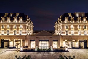 A grand hotel with symmetrical architecture, large windows, and a central entrance.