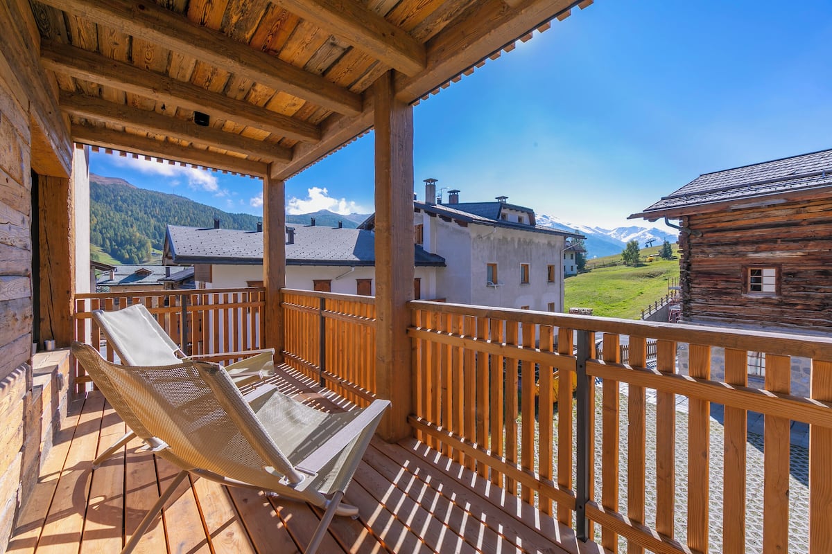 A wooden balcony with a view of a mountain landscape.