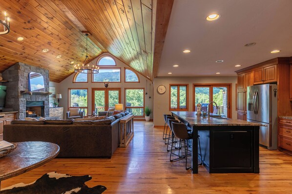 Enjoy cooking in this kitchen with a large island, bar stools, and a stone fireplace.