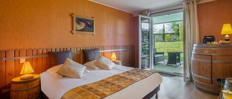 Une chambre d’hôtel avec un lit, une tête de lit en bois, un tableau, une lampe, un tonneau et une vue sur l’extérieur.
