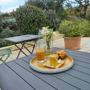 A table set with a tray containing a glass of orange juice, a cup of coffee, a pastry, and a small bowl of cream. - Domaine de l'Echassier, The Originals Relais (Chateaubernard)