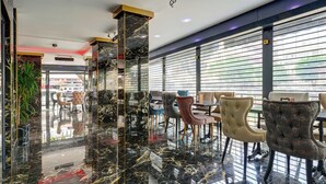 Un interior moderno con suelo de mármol, asientos confortables y grandes ventanales.