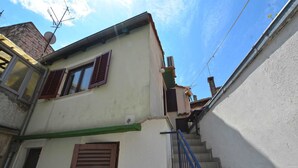 A narrow street with a building featuring a staircase and a small window with shutters. - Alan studio Apartment in Rovinj downtown (Rovinj)