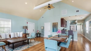 A spacious living room with a dining area, a kitchen, and a ceiling fan. - Sky Suite with Balcony Overlooking Duval Street (Key West)