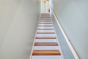 A staircase with wooden steps and white walls.