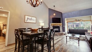 A dining area with a chandelier, a fireplace, and a sofa in a living room. - Large, Welcoming Condo With Incredible Views - WL406 by Redawning (Copper Mountain)
