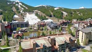 A ski resort with multiple buildings, a parking area, and a lake. - Large, Welcoming Condo With Incredible Views - WL406 by Redawning (Copper Mountain)