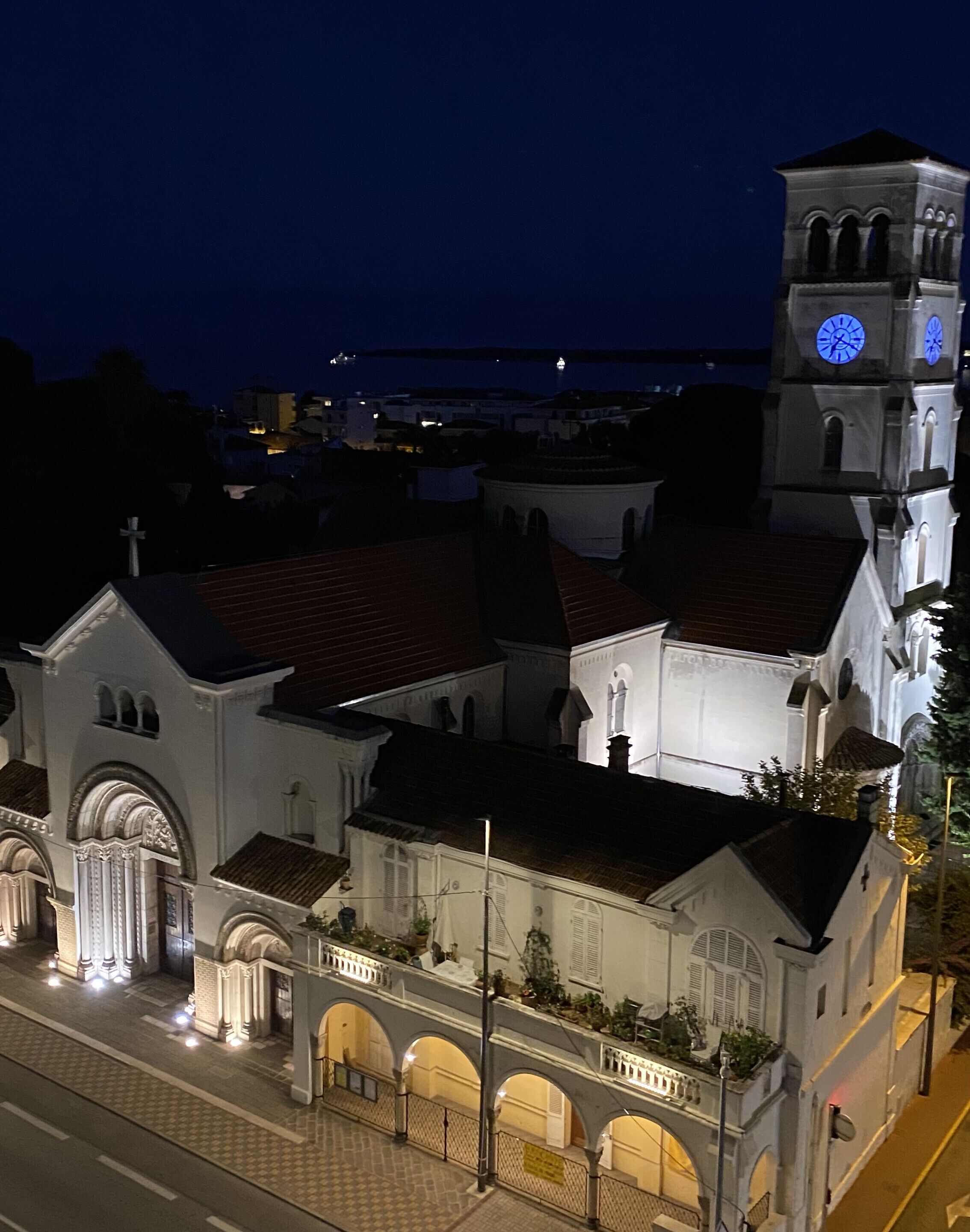 A historic church with a clock tower, arched windows, and a tiled roof.