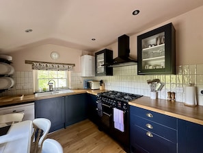 A kitchen with a stove, oven, sink, and cabinets.