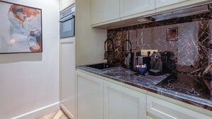 A modern kitchen with marble countertops, a coffee machine, and a sink. - St Georges - Incredible One Bedroom with a patio (Paris)
