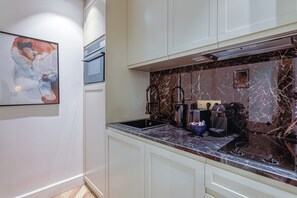 A modern kitchen with marble countertops, a coffee machine, and a sink. - St Georges - Incredible One Bedroom with a patio (Paris)