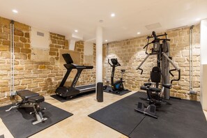 Ein Fitnessstudio mit Laufband, Gewichtbank und verschiedenen Trainingsgeräten.