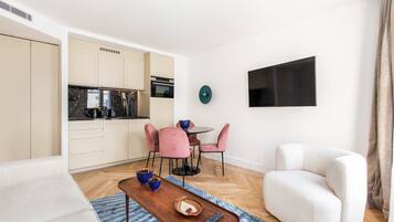 A modern living space with a kitchen, dining area, and seating.