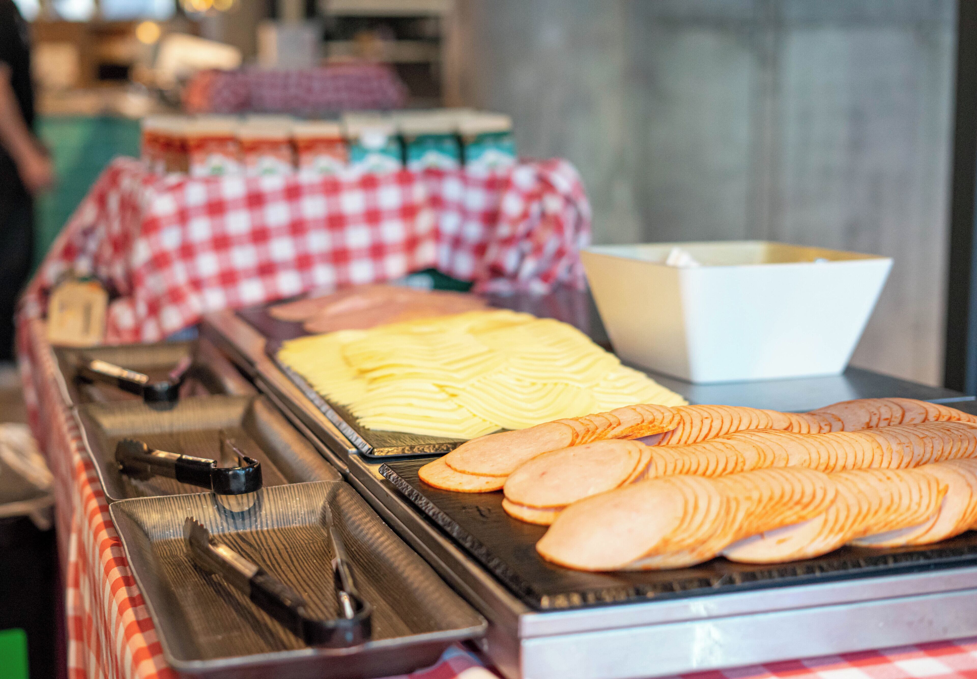 A buffet with various food items, including sliced apples and a tray of tongs.
