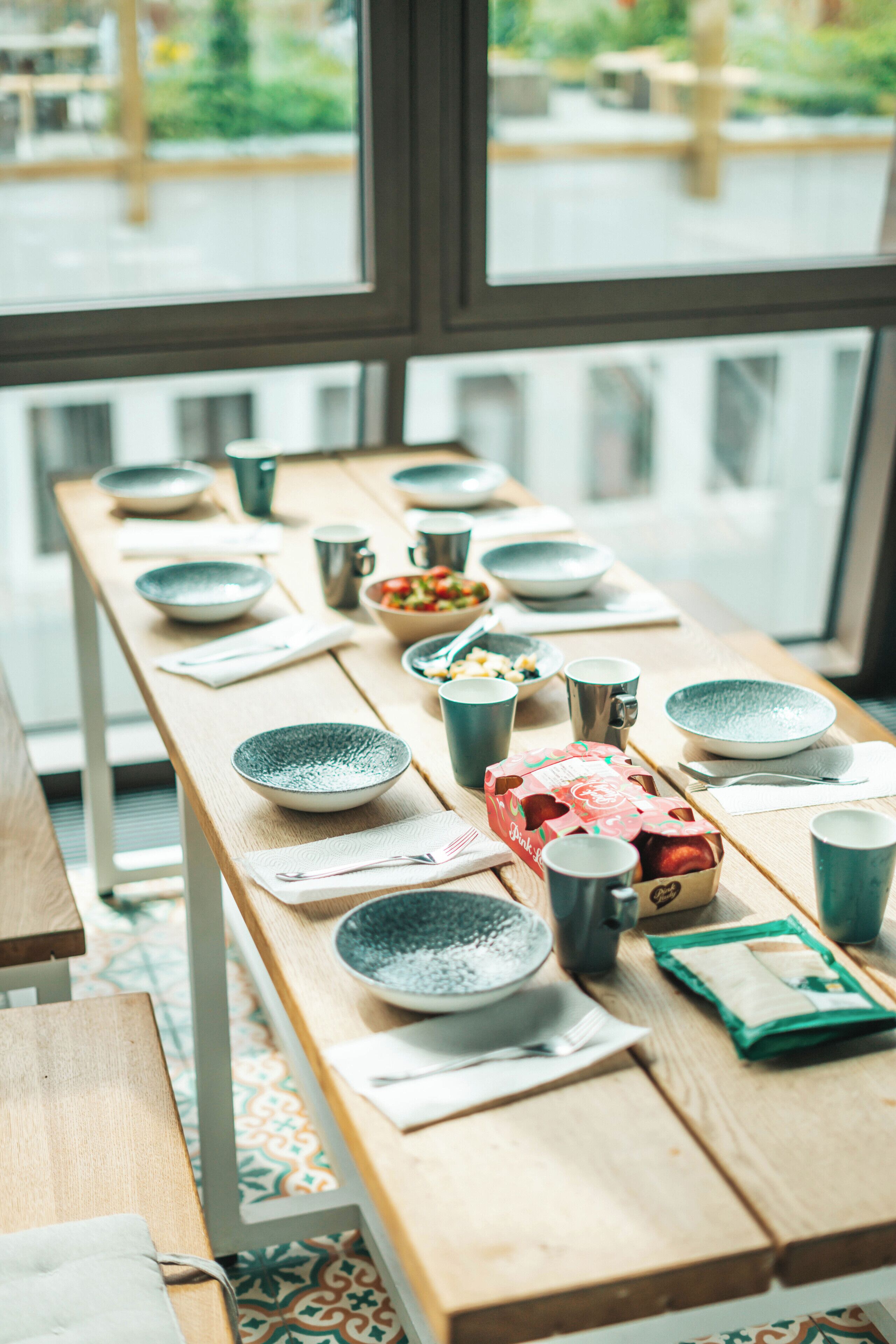 A dining table set with various bowls, cups, and a box of chocolates.