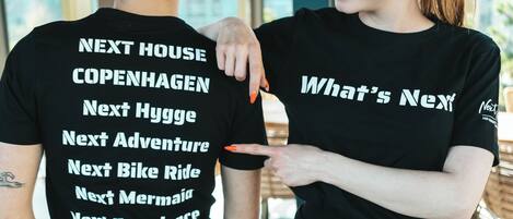 Two people wearing black t-shirts with text on the back.