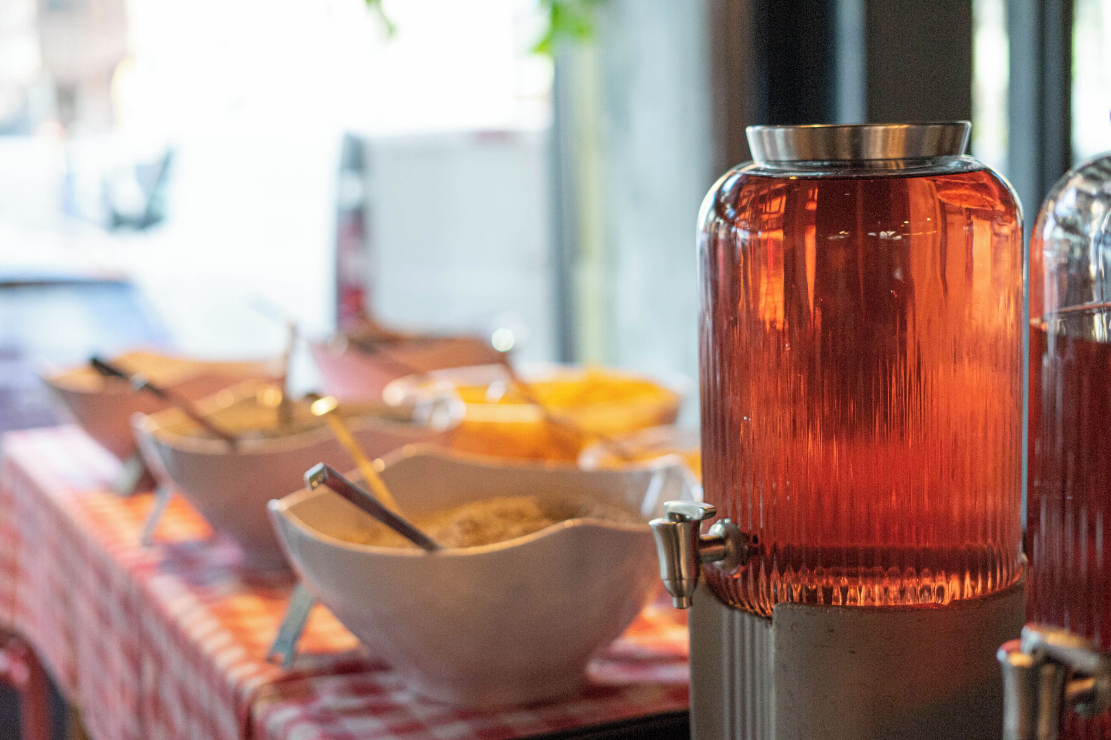 Een buffetopstelling met diverse bakken en een drankdispenser.