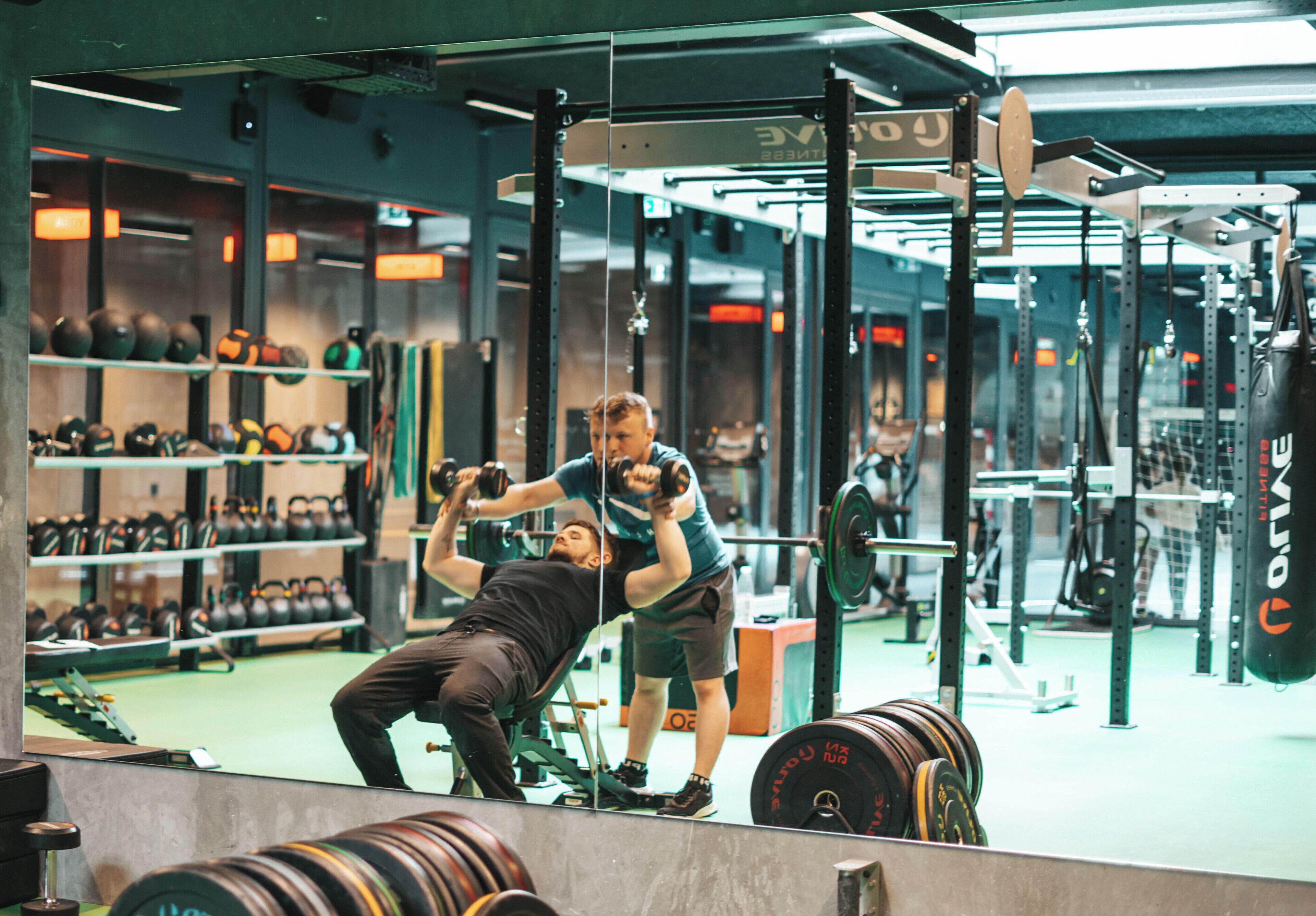 A gym with weightlifting equipment and kettlebells.