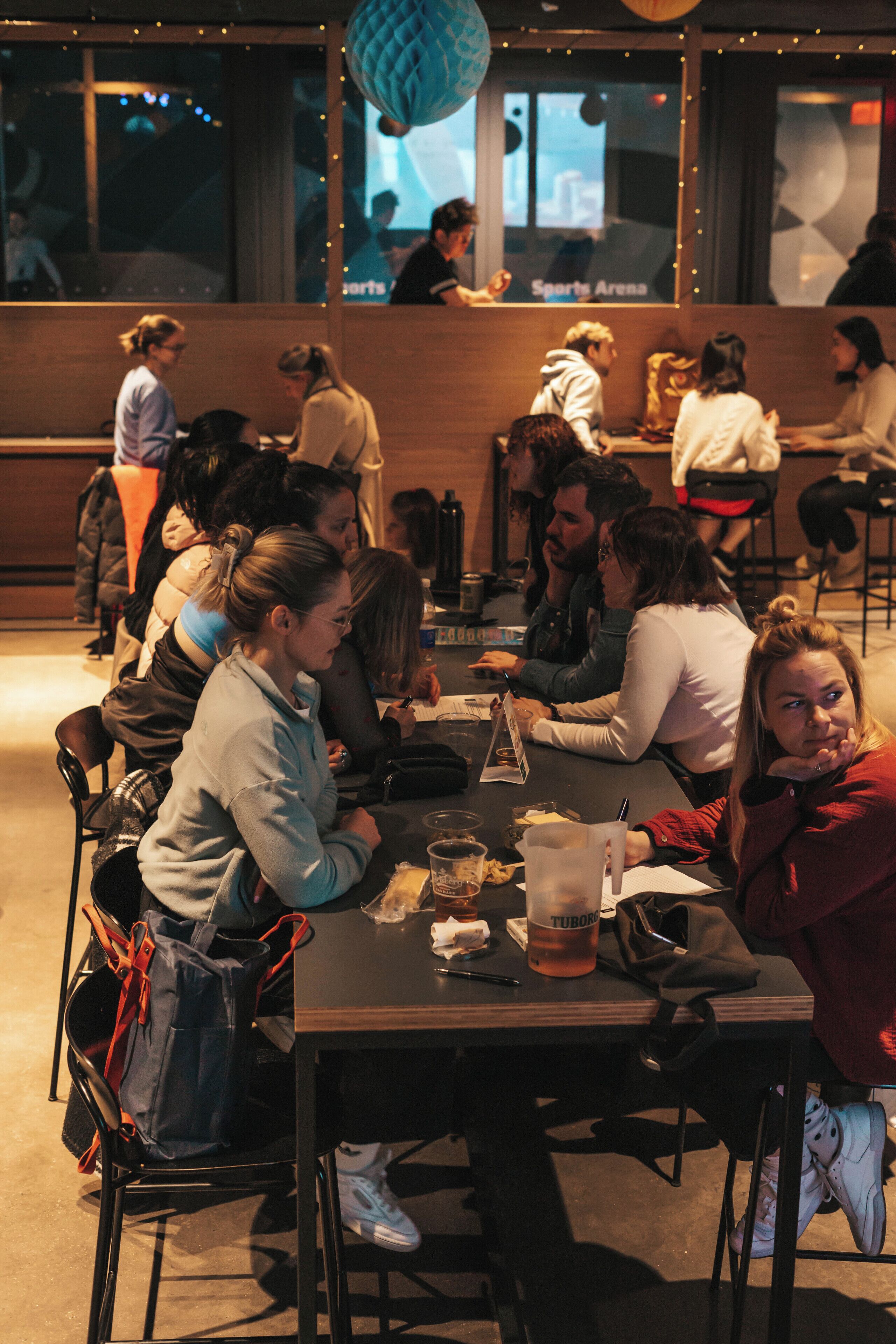 Un grupo de personas cenando en un restaurante con vista a un estadio.