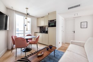 Un appartement moderne comprenant un coin repas, une kitchenette et un espace de vie.