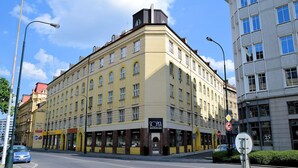A corner building with multiple storefronts, including a butcher shop and a restaurant. - Cosy Studio Apartment Near Florenc in Prague (Prague)