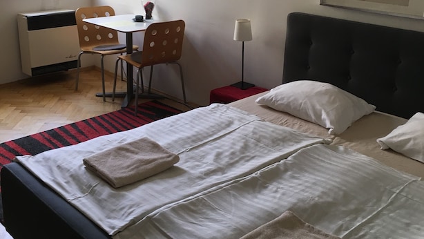 A hotel room with a bed, a desk, a chair, and a window. - Cosy Studio Apartment Near Florenc in Prague (Prague)