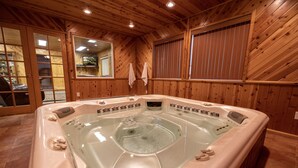 Un intérieur en bois avec un jacuzzi, des murs en bois et un miroir.