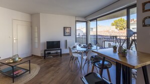 A modern living room with a dining area, large windows, and a view of the cityscape. - Terrasse en ville - Première conciergerie (Montpellier)
