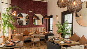 A cozy restaurant interior with a mix of seating options, including a sofa and dining tables, and a decorative mirror on the wall. - Hotel Maison Ardois La Ciudadela Marbella (Marbella)