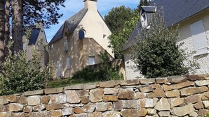 Un mur de pierre avec un bâtiment en pierre en arrière-plan.