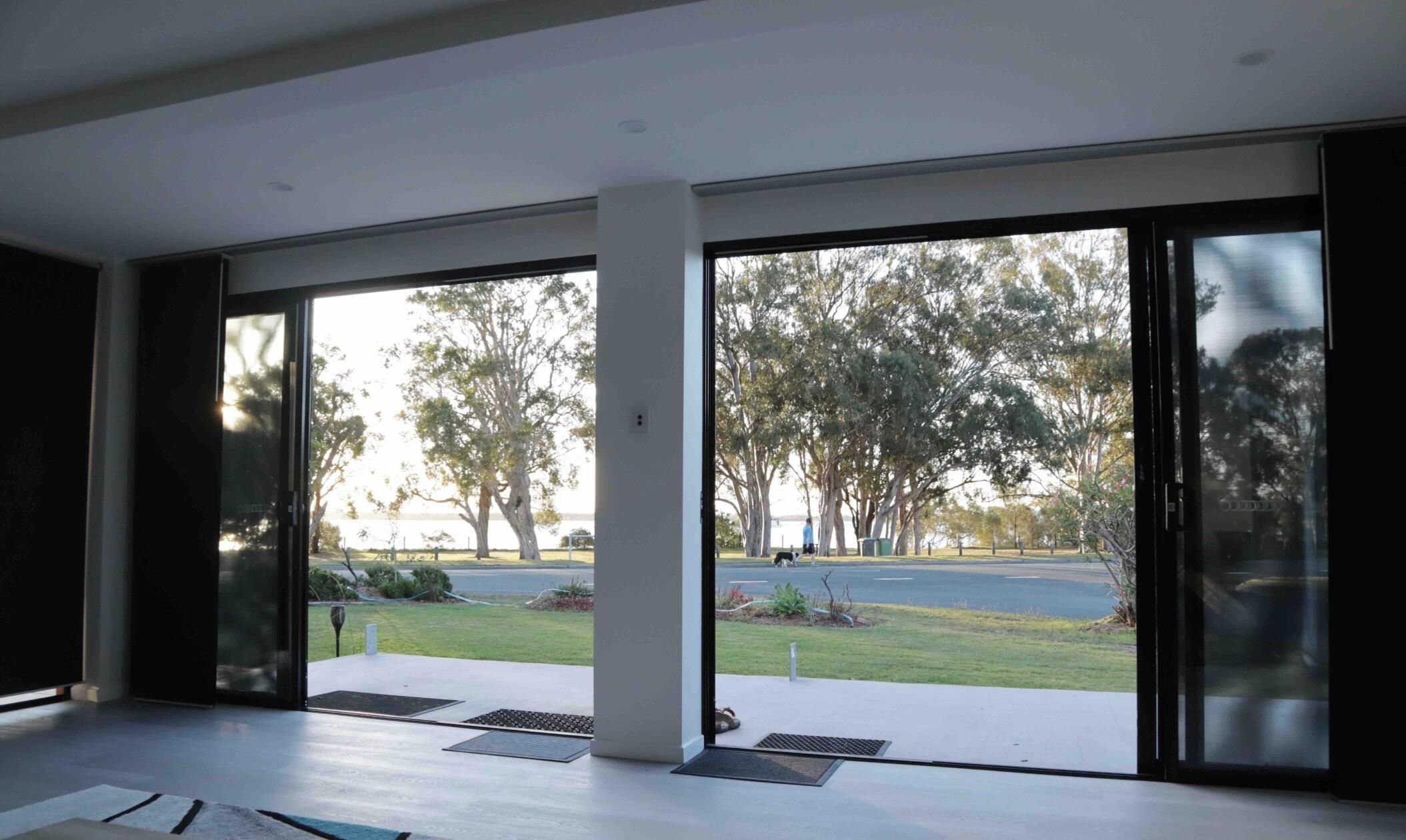 A modern interior with large sliding glass doors leading to a covered outdoor area.