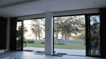 A modern interior with large sliding glass doors leading to a covered outdoor area.