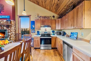 A kitchen with wooden cabinets, a stove, a microwave, and a dishwasher. - Game Room & Panoramic Valley Views - Pool, Ping Pong, Pet-Friendly (Fairplay)