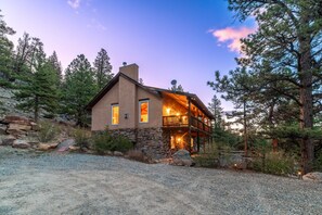 A two-story house with a stone facade, a balcony, and a gravel driveway. - Game Room & Panoramic Valley Views - Pool, Ping Pong, Pet-Friendly (Fairplay)