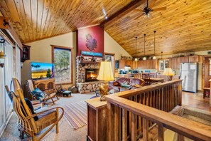 A spacious living area with a fireplace, comfortable seating, and a view of the outdoors. - Game Room & Panoramic Valley Views - Pool, Ping Pong, Pet-Friendly (Fairplay)