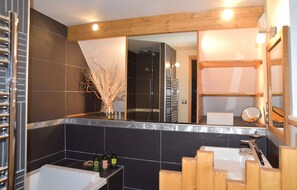 A modern bathroom with a bathtub, a shower, and a vanity with a mirror. - L'ALBARON 3CH,WIFI,PARKING, 100 m PISTES (Val-d´Isère)