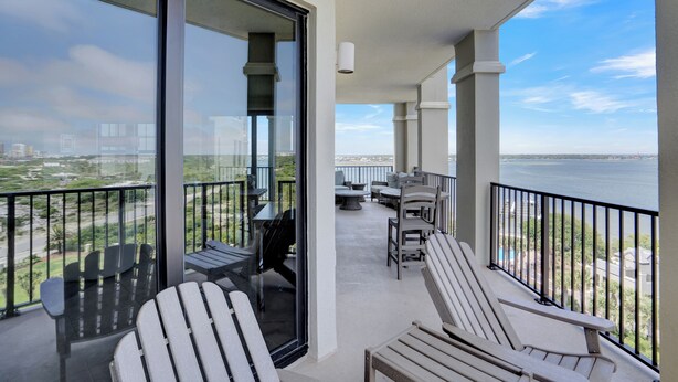 Een balkon met zitplaatsen, een tafel en uitzicht op het water.