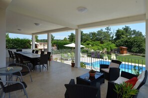 A covered patio area with a pool, dining table, and chairs. - Villa Margherita with private pool (Kanfanar)
