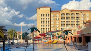 A hotel pool area with multiple slides and palm tree sculptures.