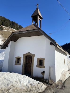 A small white church with a bell tower, wooden door, and two small windows. - Apartment 100 m2 Megève Centre near Church -Skis at feet (Megève)