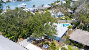 A residential area with a swimming pool, houses, and a marina in the background.
