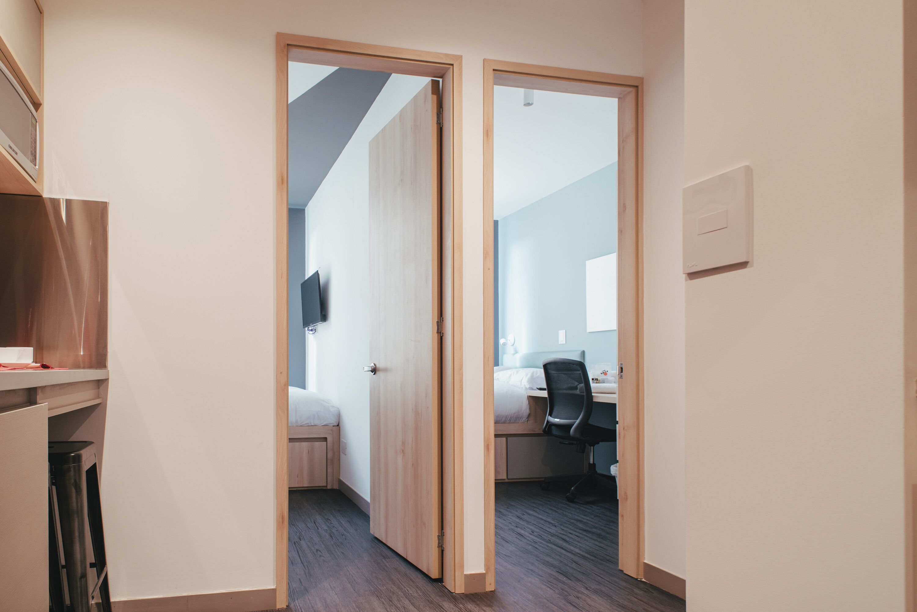 Un dormitorio moderno con un armario de madera, un escritorio y una silla.