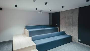 Una sala de cine moderna con asientos escalonados y un proyector.