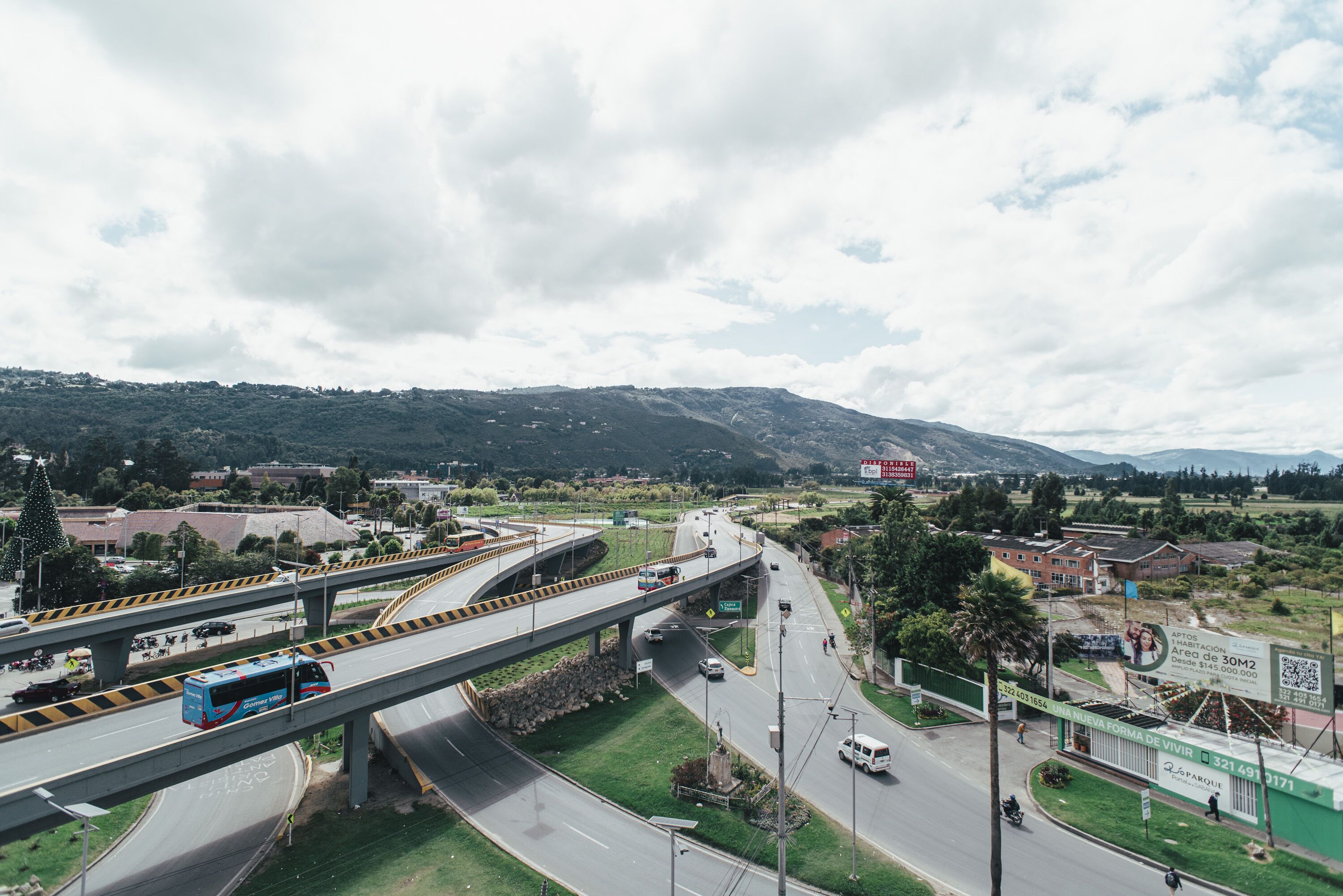 A highway overpass with multiple lanes, a bus, and a pedestrian crossing.