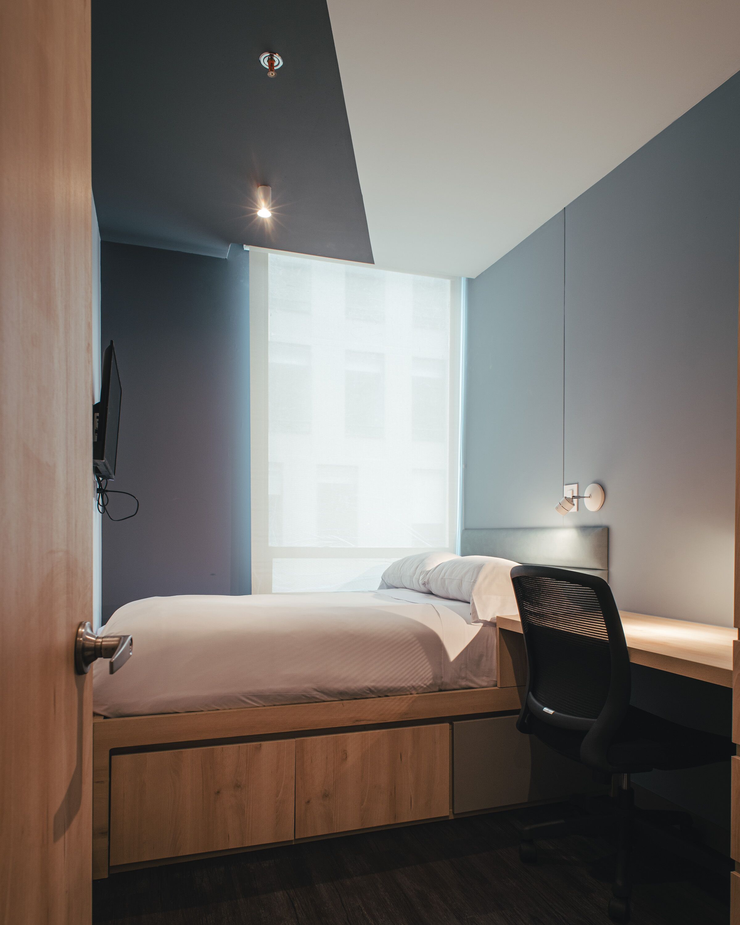 Une chambre à coucher avec un lit, un bureau et une chaise.