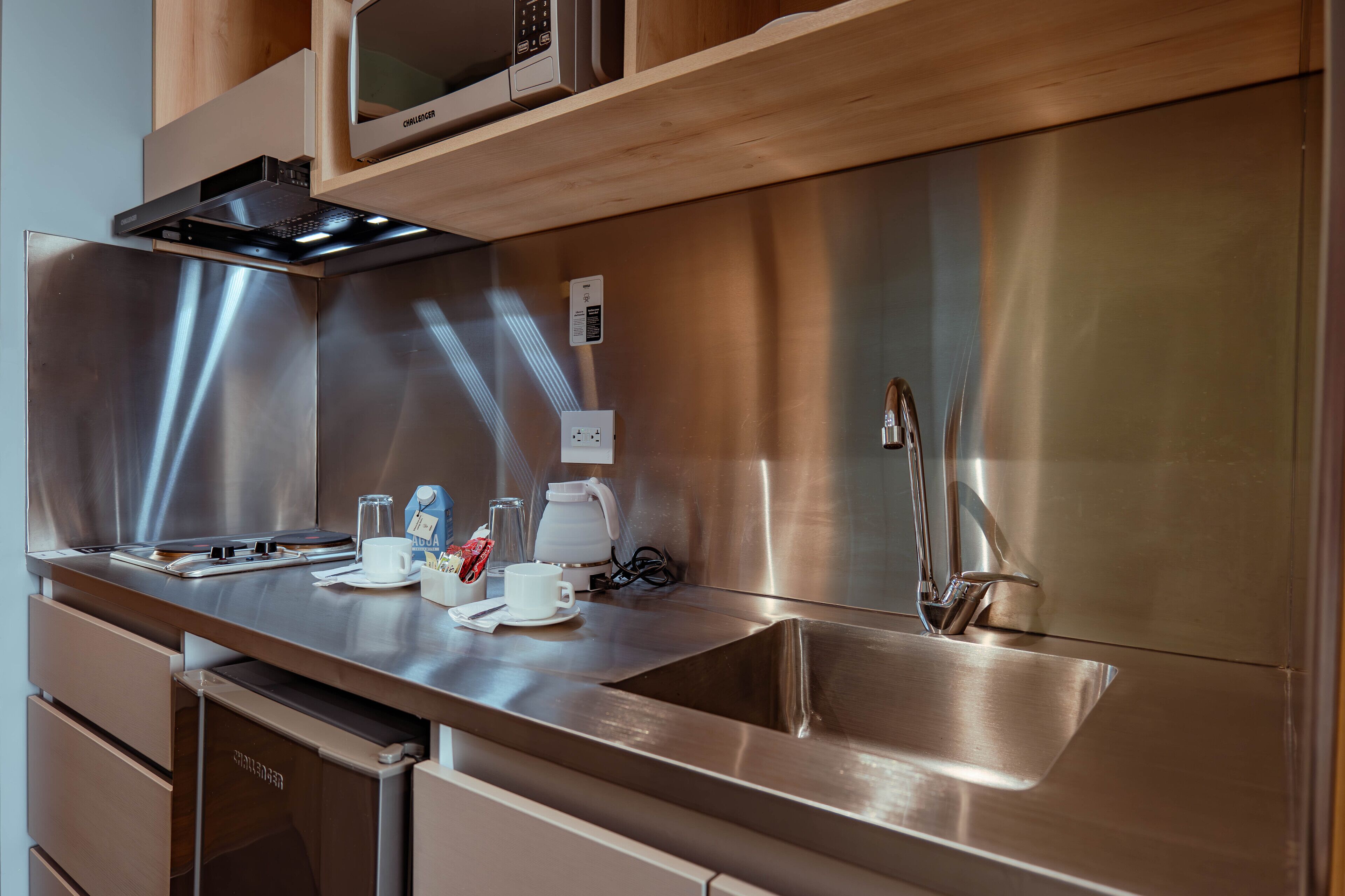 A modern kitchen with stainless steel appliances, a built-in microwave, and a coffee maker.