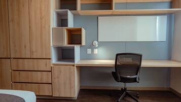 Un dormitorio moderno con un armario de madera, un escritorio con silla y una cama.
