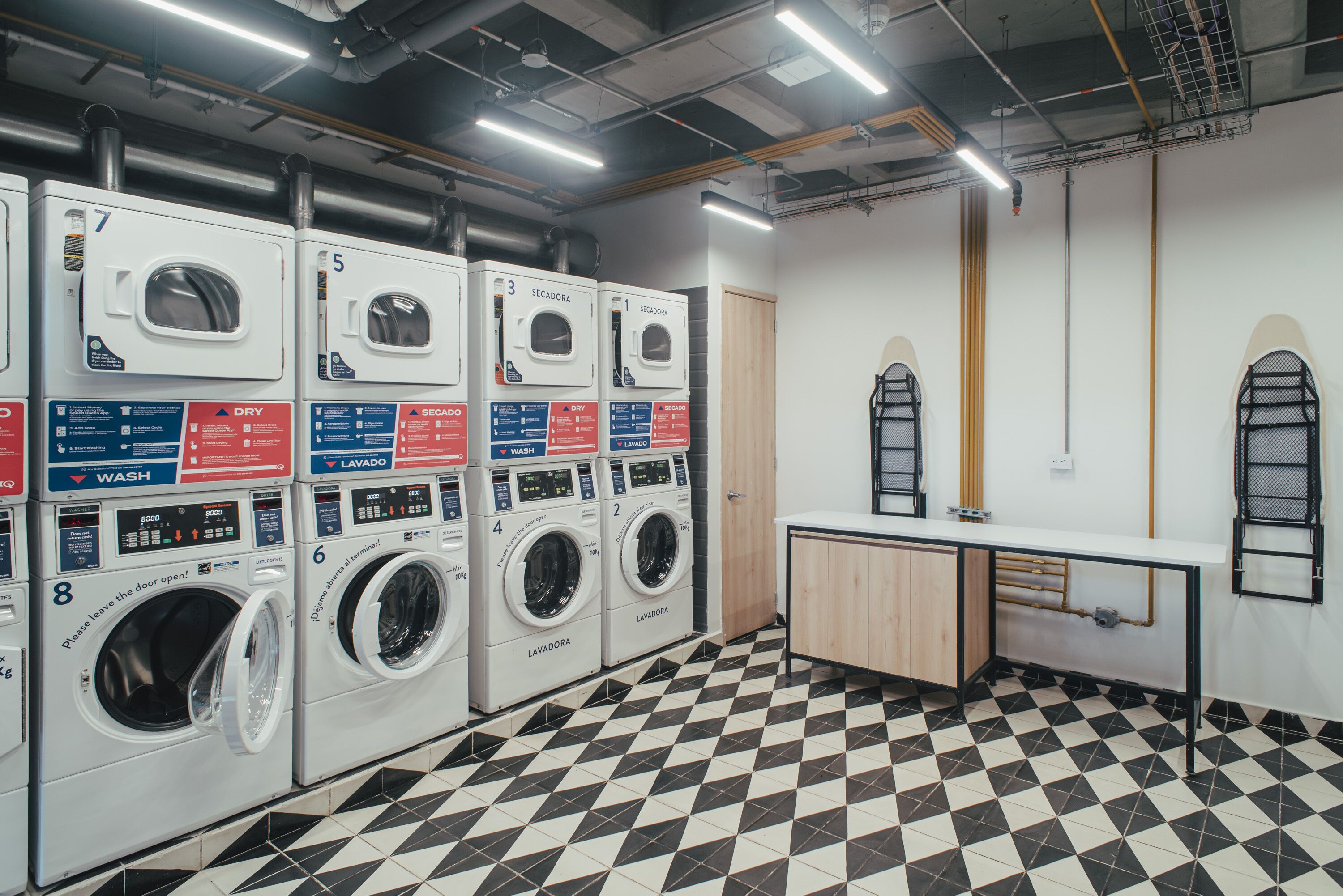 Een wasserette met meerdere wasmachines, een wasbak en een betegelde vloer.