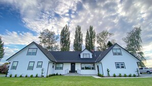 A two-story house with a front porch, a garage, and a well-maintained lawn.